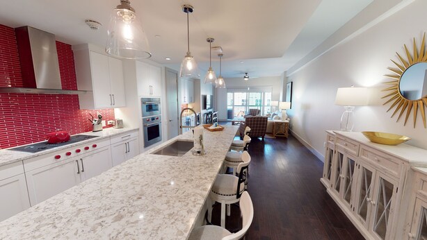 A modern kitchen with a large island, stainless steel appliances, and pendant lighting. - Located 200 feet from the stadium, WestGate is in the Center of Alabama football (Tuscaloosa)