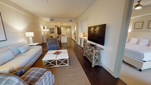 A modern hotel room with a large bed, a sofa, a coffee table, a TV, and a kitchen area in the background. - Located 200 feet from the stadium, WestGate is in the Center of Alabama football (Tuscaloosa)