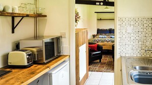 A compact kitchen with a microwave, toaster, and sink. - 1 bedroom accommodation in Great Hockham, near Thetford (Great Hockham, near Thetford)