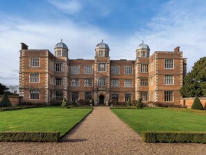 A large, historic building with symmetrical architecture, featuring two prominent towers and a central entrance.