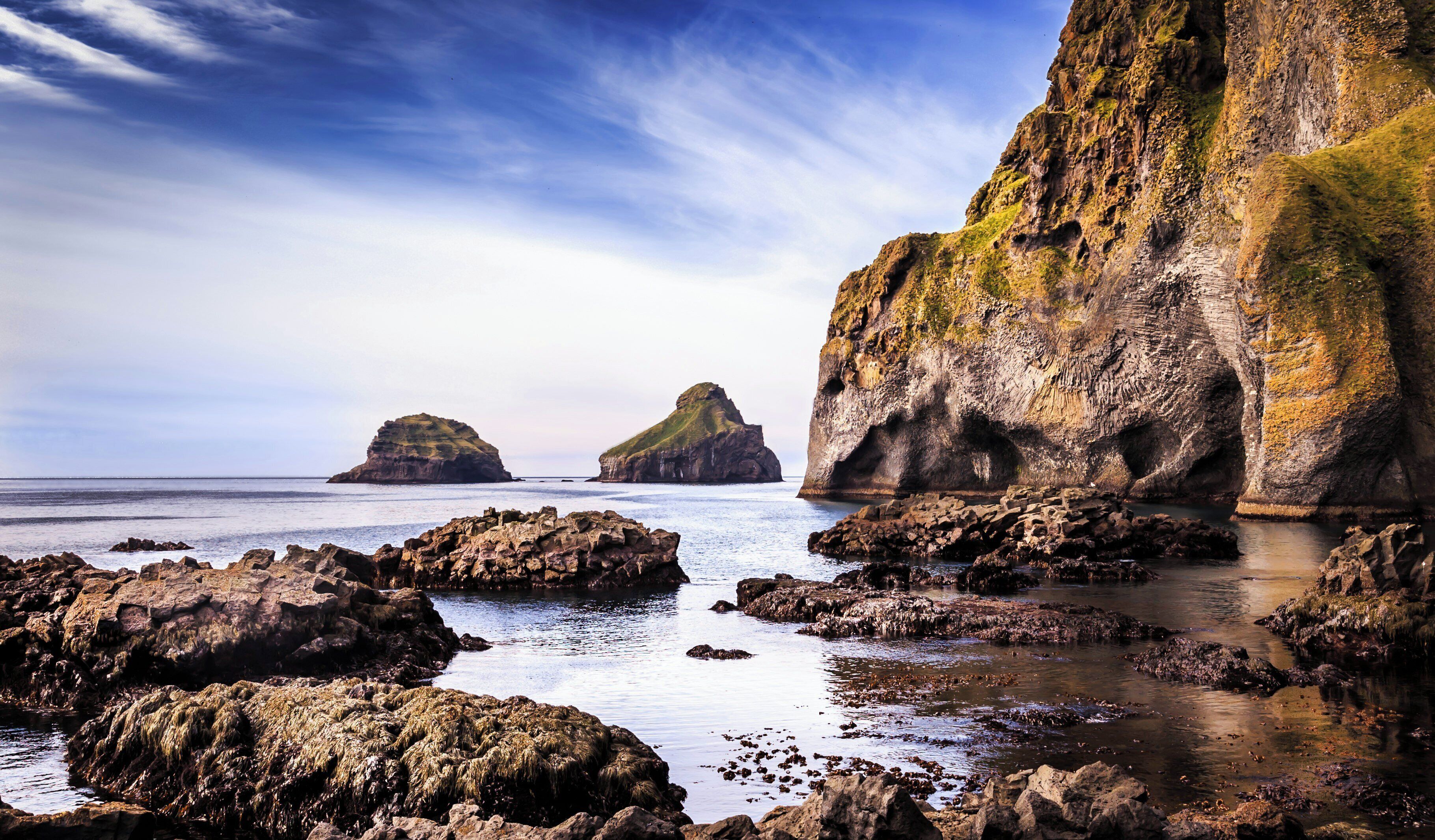 A coastal landscape with rocky terrain and two prominent rock formations.