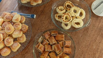 Een tafel met verschillende gebakjes, waaronder gebak en koekjes.