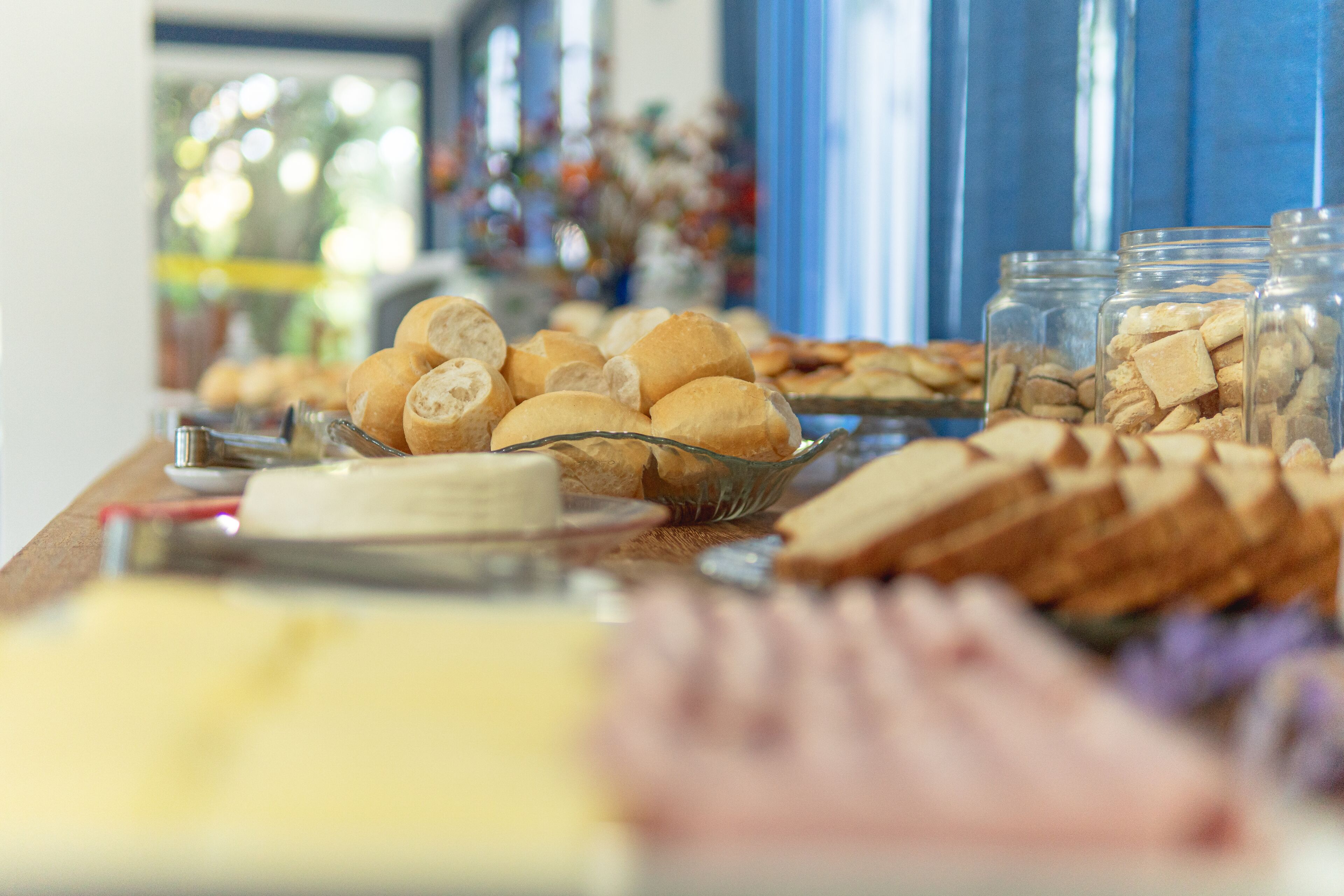 Una mesa de buffet con diferentes opciones de comida, como pan, pasteles y frascos de nueces.