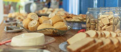 A buffet table with various breads and pastries.