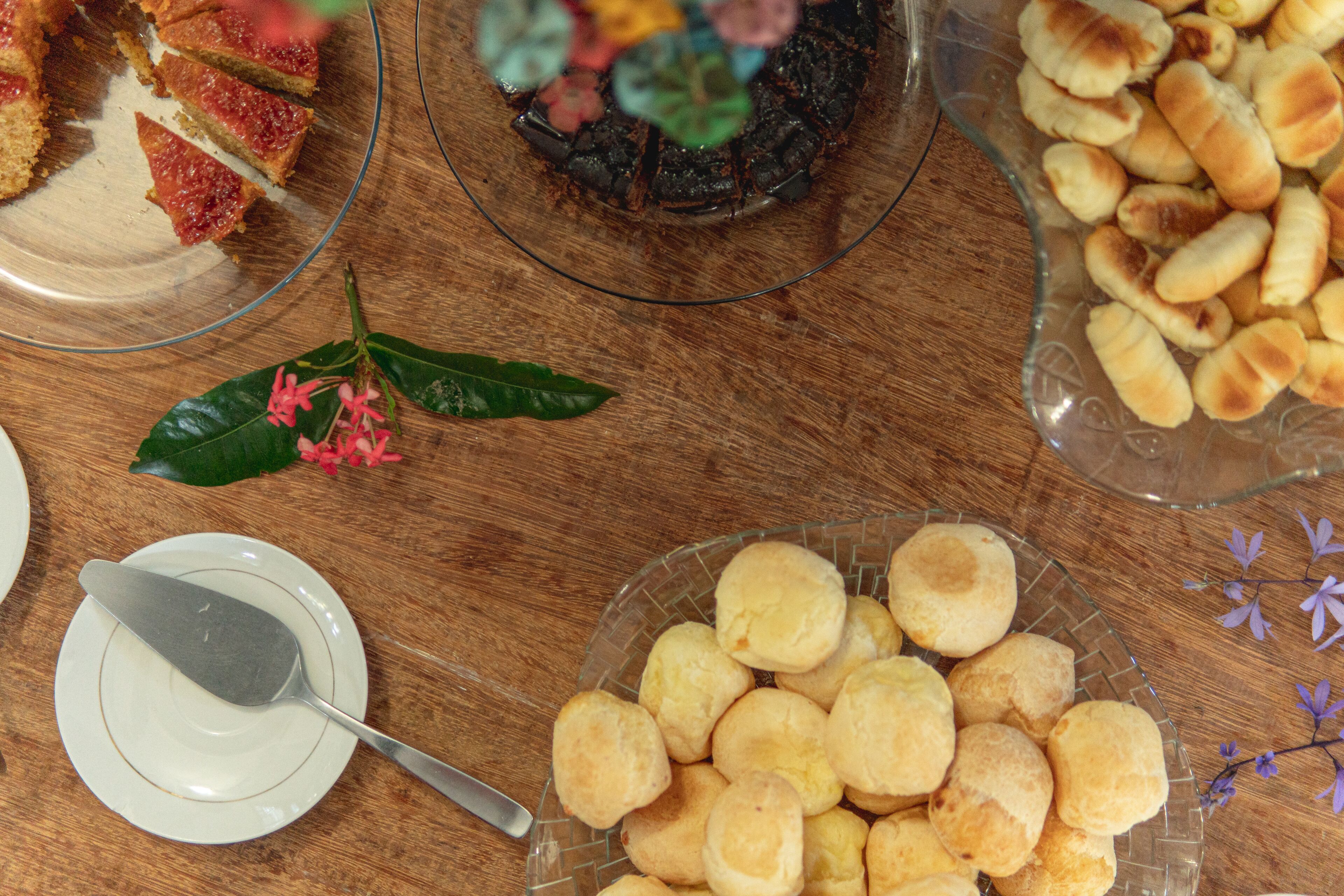 A table with various food items, including a plate of biscuits and a plate with a slice of cake.
