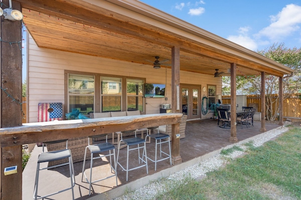 Bar with 4 stools overlooking yard. Cedar ceiling and fans.
