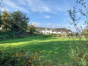 A grassy field with a white building in the background.