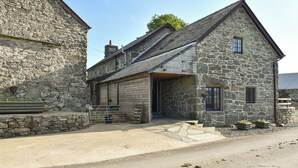 A stone building with a gabled roof and a small porch area.