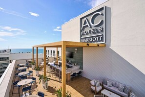 Terraza en la azotea con mobiliario exterior y vista al océano.