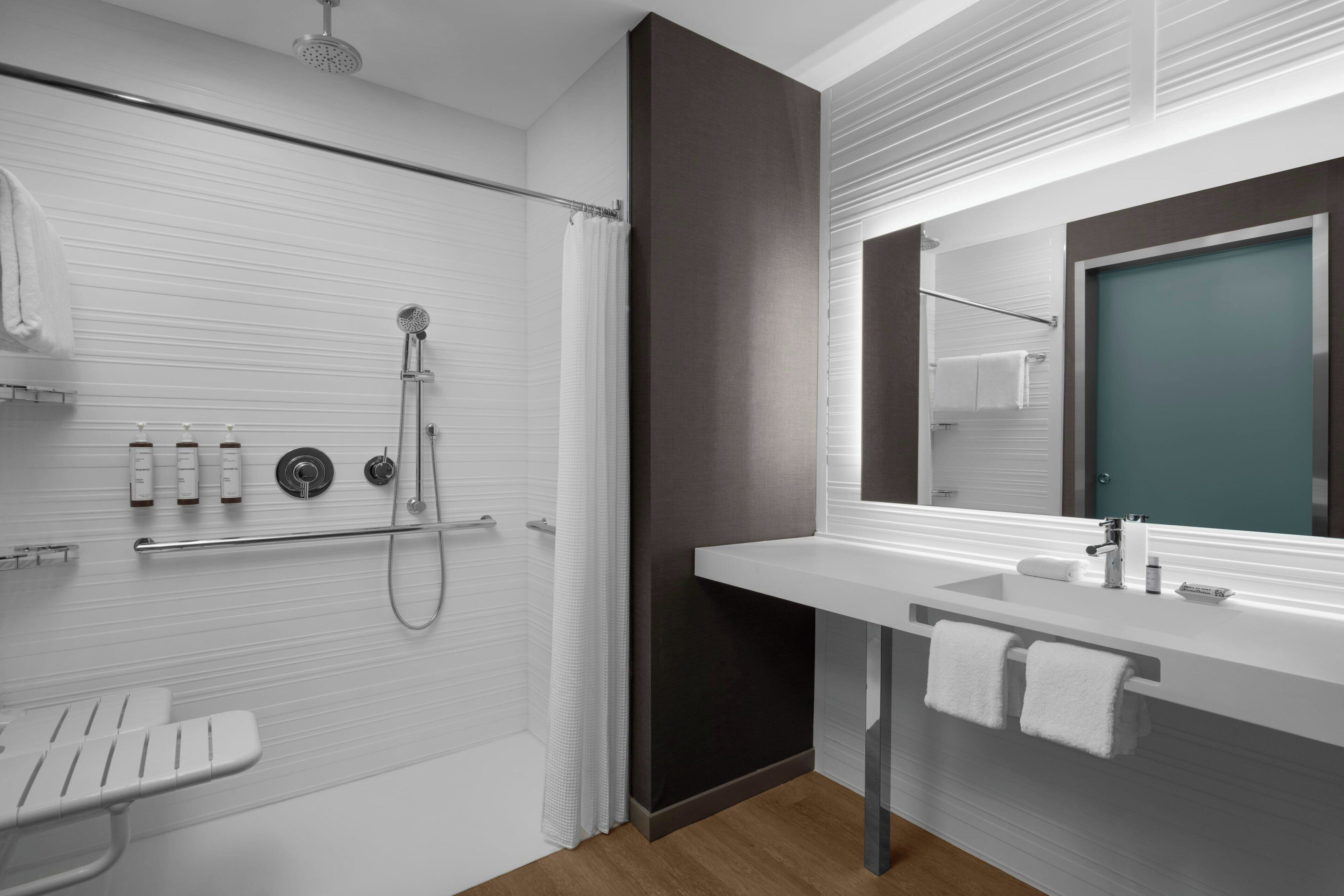 A modern bathroom with a shower, toilet, and sink.