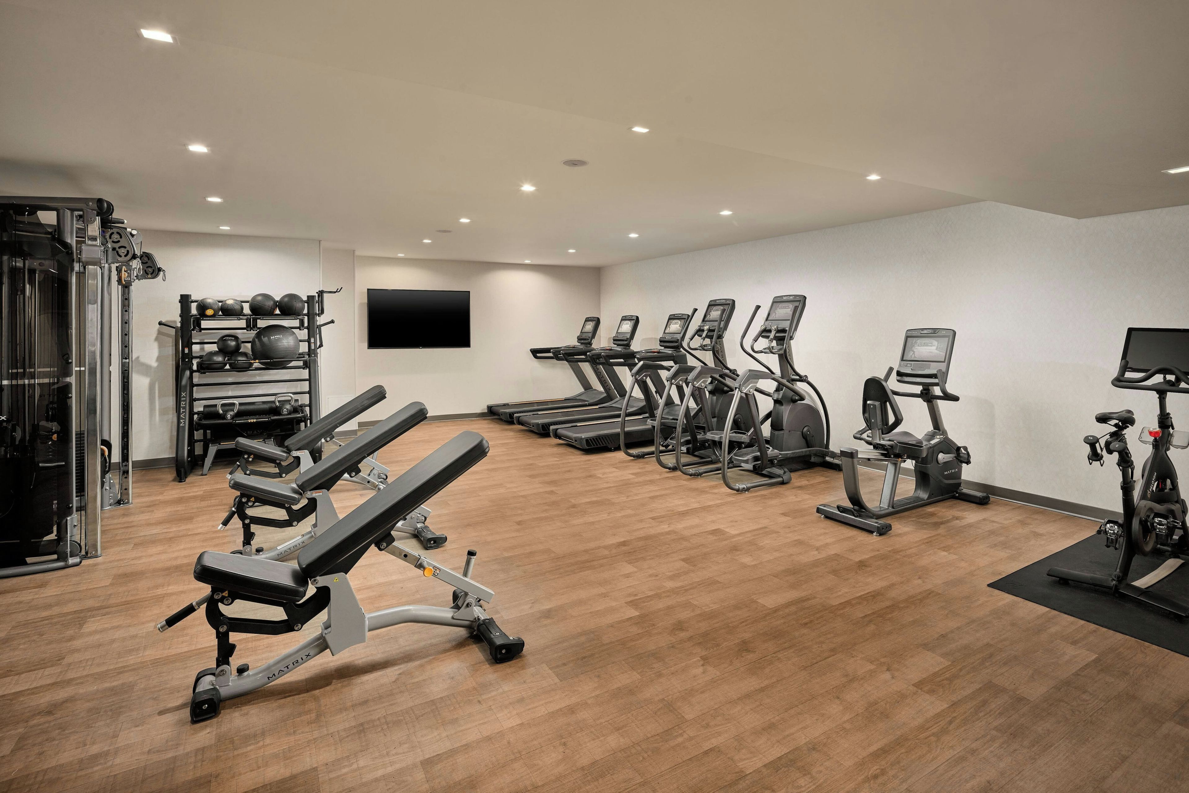 Une salle de sport équipée de tapis de course, de vélos elliptiques et de matériel de musculation.