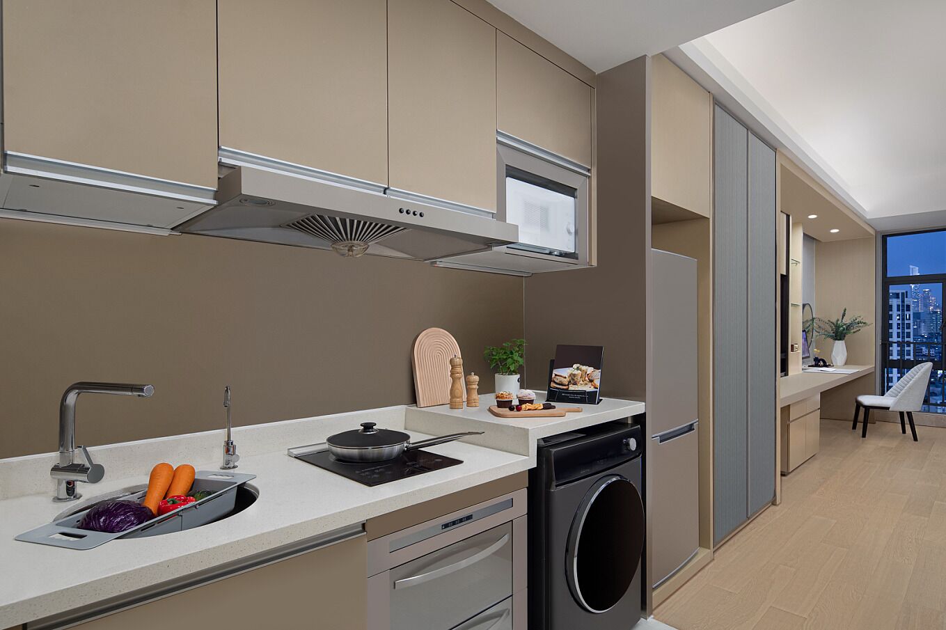 A modern kitchen with a built-in dishwasher, a large window offering a city view, and a compact layout.