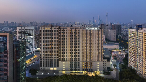 Un edificio de gran altura con el nombre "SOMERSET" visible. Presenta un diseño arquitectónico moderno con una cuadrícula de ventanas y un techo plano.