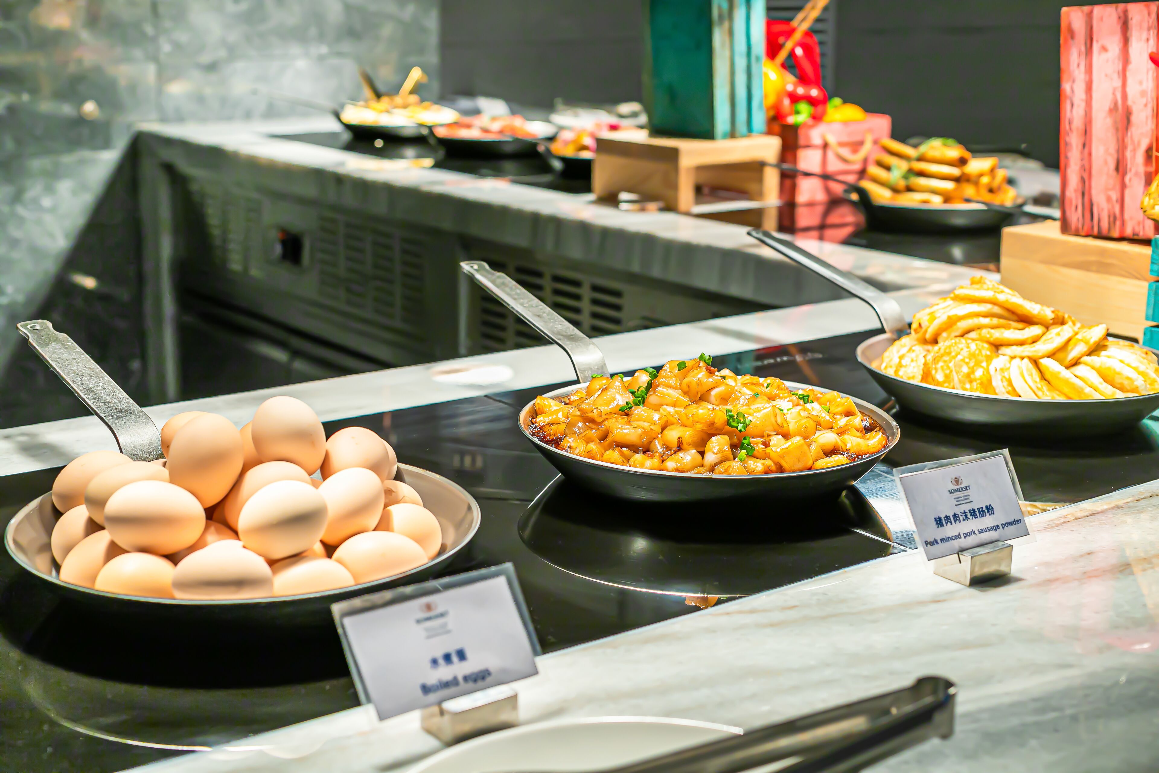 Un buffet con diversi piatti, tra cui uova, pasta e altre preparazioni.