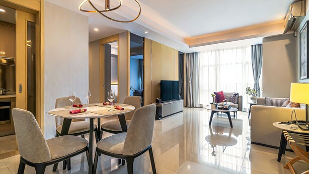 Une chambre d’hôtel moderne comprenant un coin repas, un salon et une cuisine.