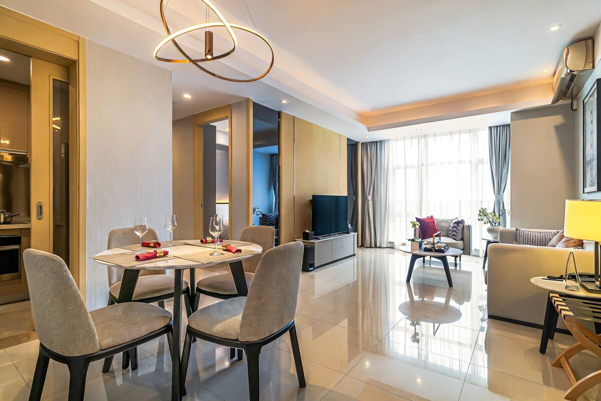 Una habitación de hotel moderna con comedor, sala de estar y cocina.