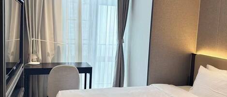 Een hotelkamer met een bed, een bureau, een stoel en een airconditioning.