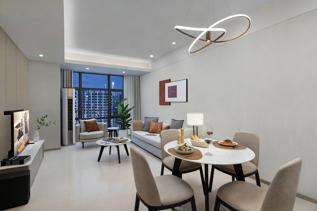 Habitación de hotel moderna con zona de comedor, sofá, televisor y vista a la ciudad.