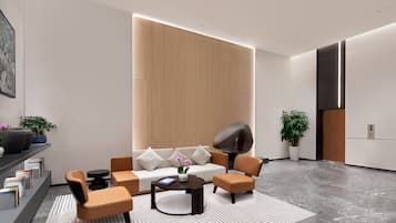 Ein modernes Wohnzimmer mit Sofa, Sesseln, Couchtisch und Kamin.