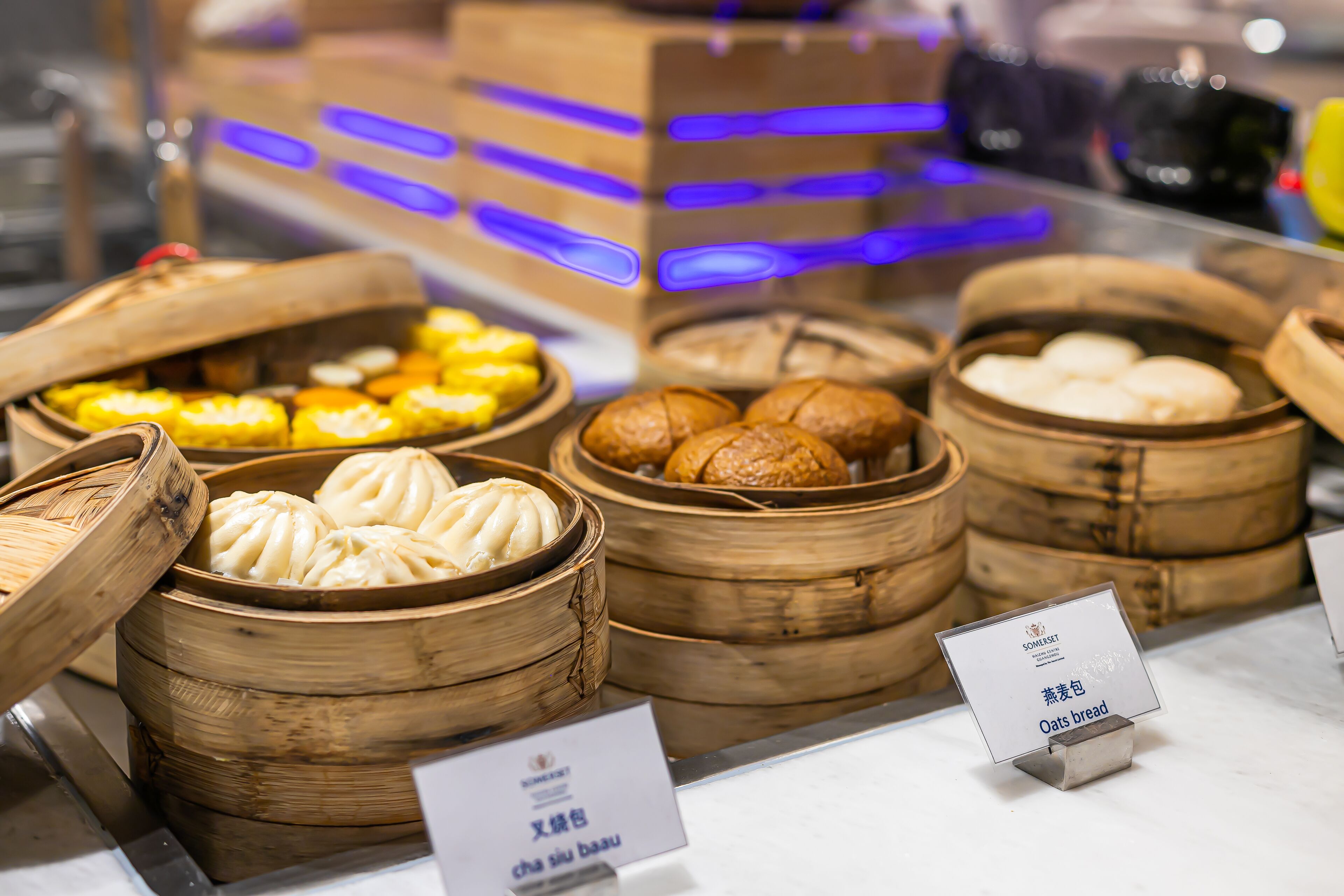 A display of various steamed buns in bamboo baskets, with labels indicating different types.