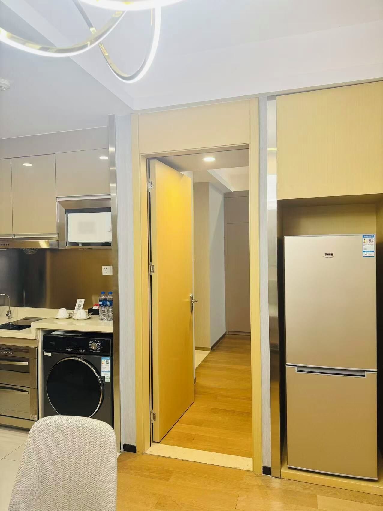 A modern kitchen with a dishwasher, microwave, and a refrigerator.