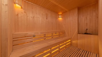 A wooden sauna with benches and wall-mounted lights.