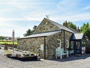 A stone building with a sloped roof, a small porch, and a gravel driveway. - 2 bedroom accommodation in Westgate, Near Stanhope (Westgate, Near Stanhope)