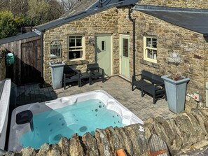 A stone building with a hot tub, outdoor seating, and a wooden fence. - 2 bedroom accommodation in Westgate, Near Stanhope (Westgate, Near Stanhope)