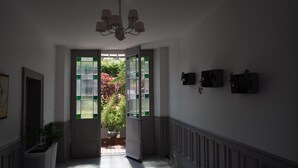 Um corredor com porta dupla que dá para um jardim.