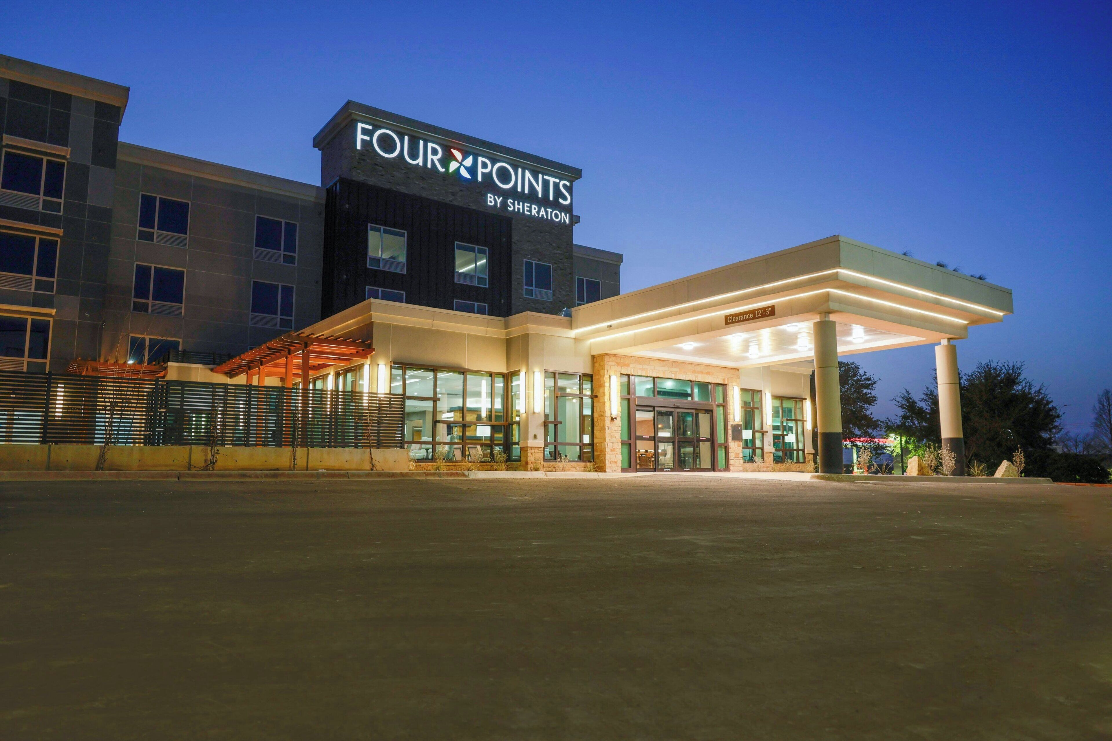 A Four Points by Sheraton hotel with a modern design, large windows, and a spacious entrance area.