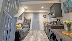 Een moderne keuken met een inbouwoven, magnetron en een houten aanrecht.