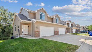 A modern two-story townhouse with a garage, a covered patio, and a well-maintained lawn. - Spacious 4 BR Home Convenient Location (Tiffin)