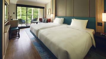 A hotel room with two large beds, a desk, and a chair.