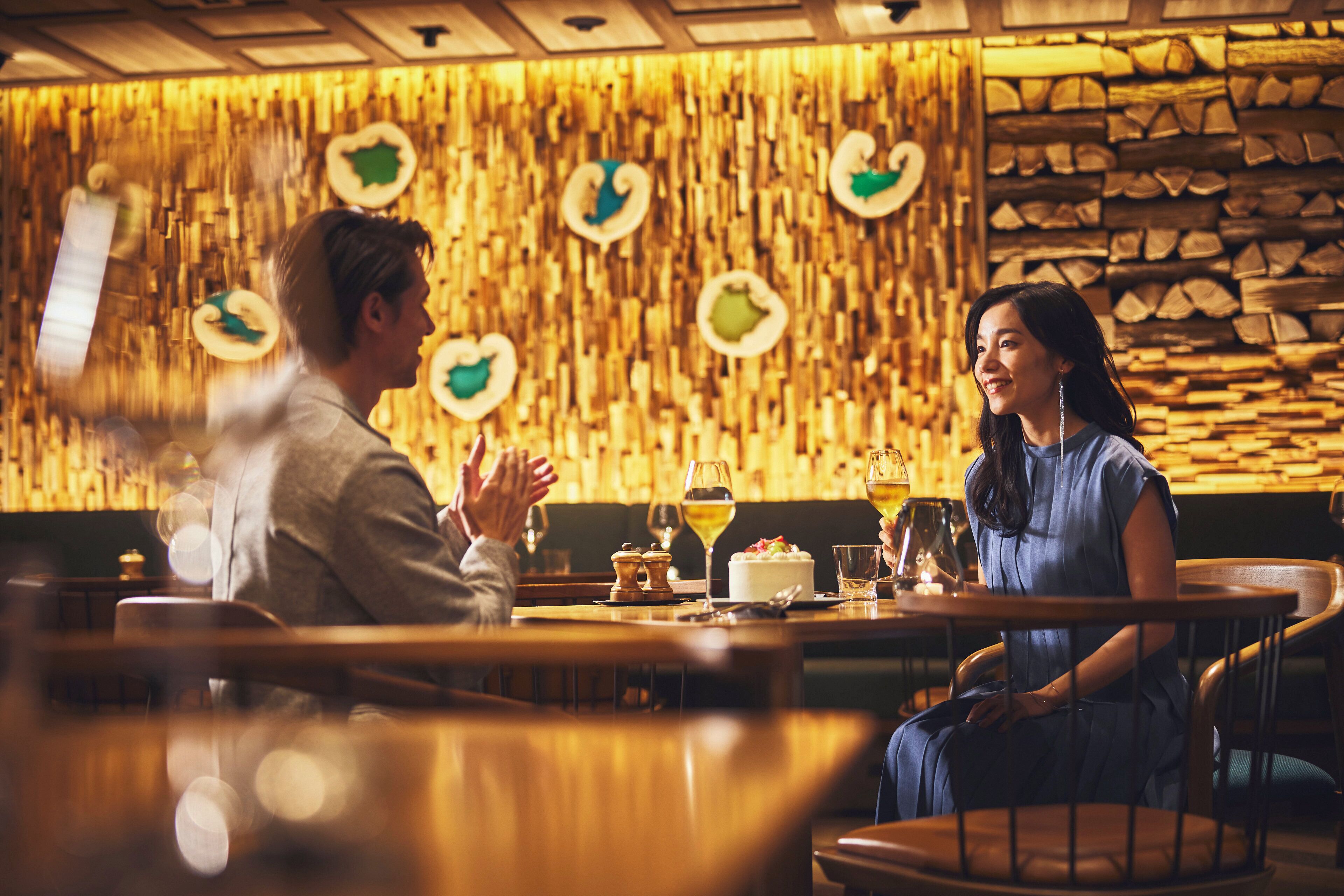 A restaurant with a wooden wall and a stack of firewood.