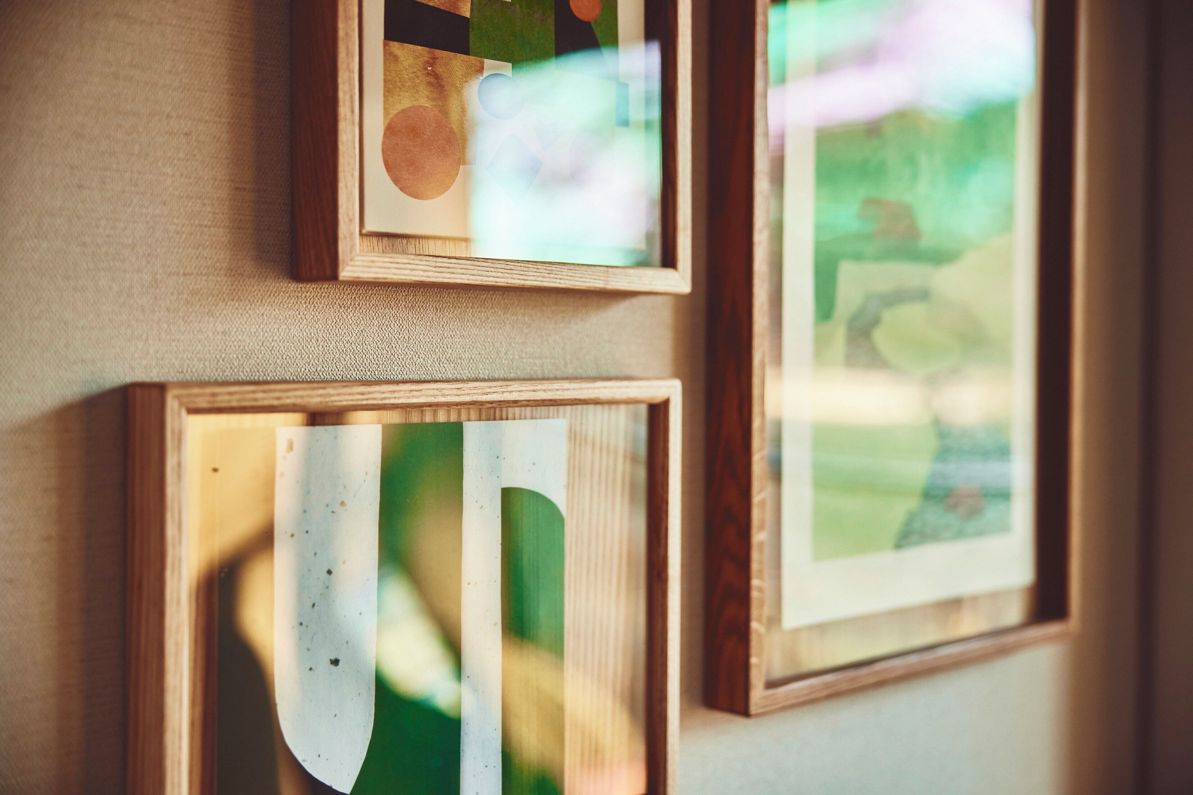 Three framed artworks on a wall.