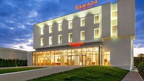 Een modern gebouw met het bord "RAMADA BY WYNDHAM" duidelijk zichtbaar.