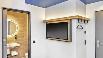 Ein modernes Badezimmer mit einem Holzbadezimmer-Möbel, einem großen Spiegel und einem integrierten Fernseher.