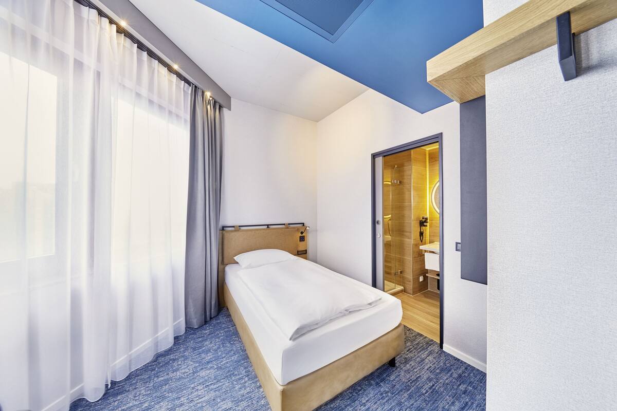 Une chambre d’hôtel comprenant un lit, une salle de bain et un espace douche.