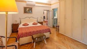 A bedroom with a bed, bedside tables, a lamp, a chair, a wardrobe, and a mirror. - Large flat between two parks in central Florence-ideal for families/small groups (Firenze)