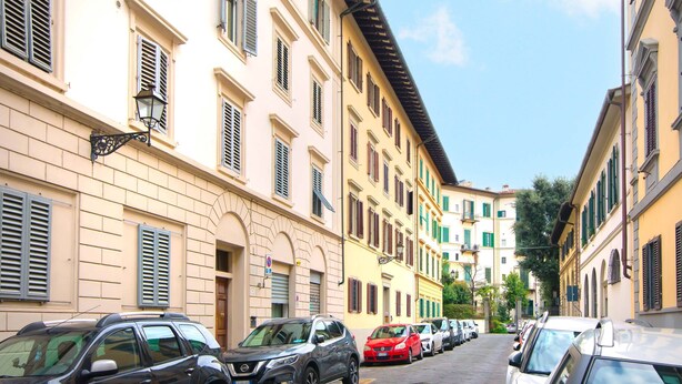 A street lined with parked cars and buildings with multiple windows and shutters. - Large flat between two parks in central Florence-ideal for families/small groups (Firenze)