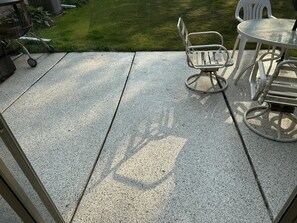 A patio area with a concrete floor, metal chairs, and a table. - Relax Near Everything in Milwaukee (Wauwatosa)