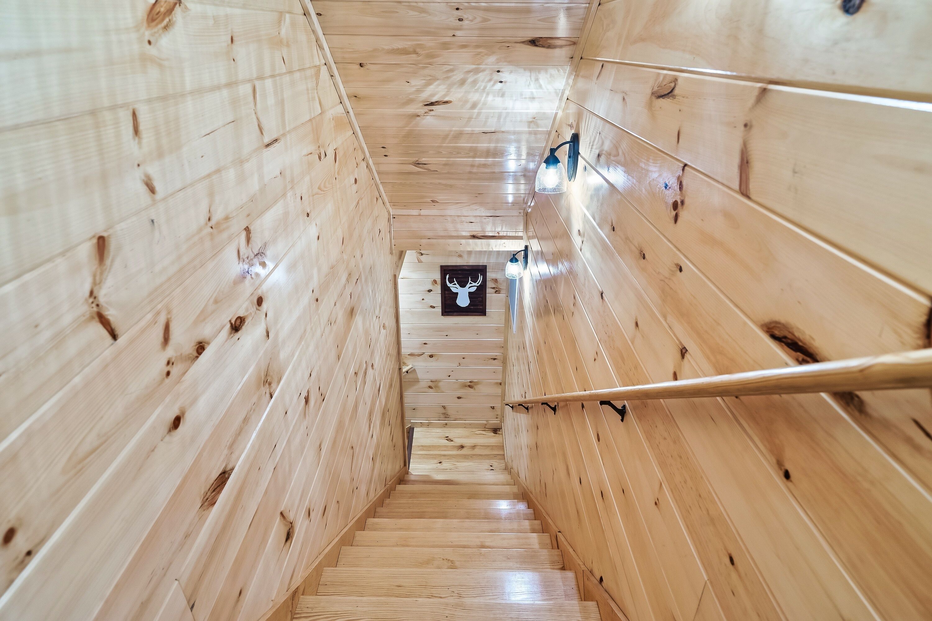 Una scala in legno con un quadro di un cervo in cima.
