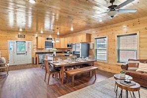Cozy cabin with a spacious living area, comfortable sofa, and dining table, perfect for social gatherings and meal preparation.