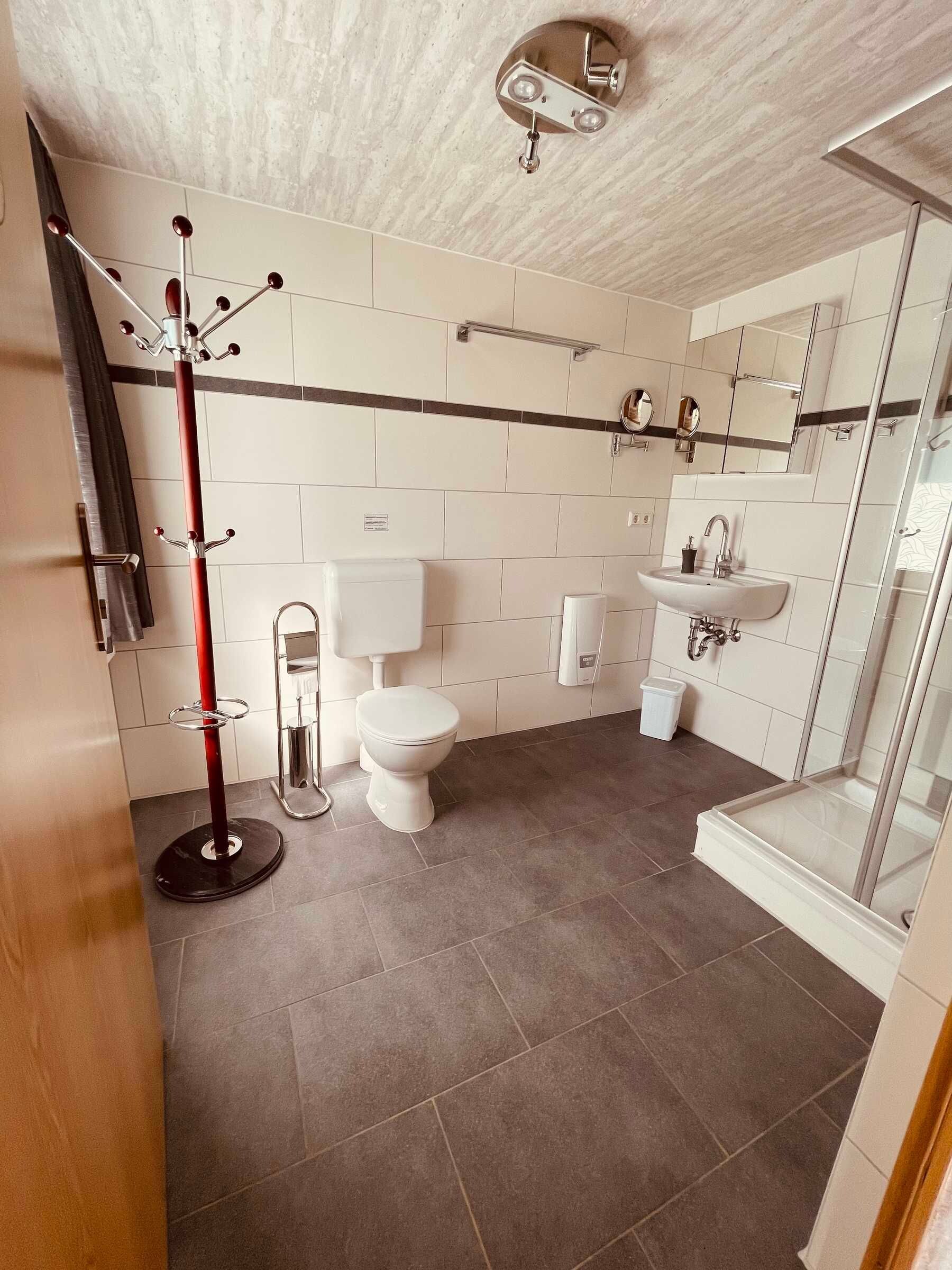 Un baño moderno con inodoro, lavabo y ducha.