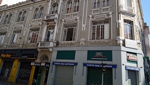 Un edificio histórico con varias ventanas y balcones, con letreros que indican un hotel y un negocio relacionado con antenas.
