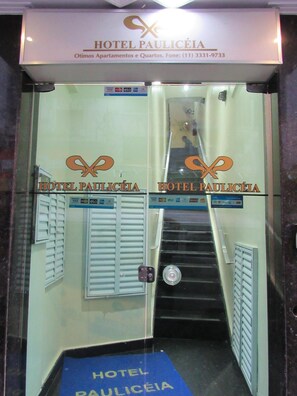 A hotel entrance with a sign reading "HOTEL PAULICÉIA" and a staircase leading inside.