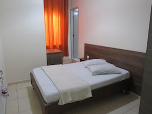 A hotel room with a bed, a nightstand, a desk, and a chair. - Hotel Pauliceia (São Paulo)