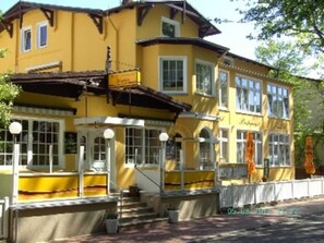 A yellow building with multiple windows and a balcony.
