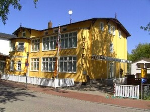 Un edificio giallo con un cartello che riporta le scritte 'HOTEL' e 'Hotel'.