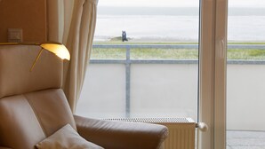 A room with a view of the sea, a chair, and a lamp. - N36 (BC.a5) - Stranddomicil Steiner (Büsum)